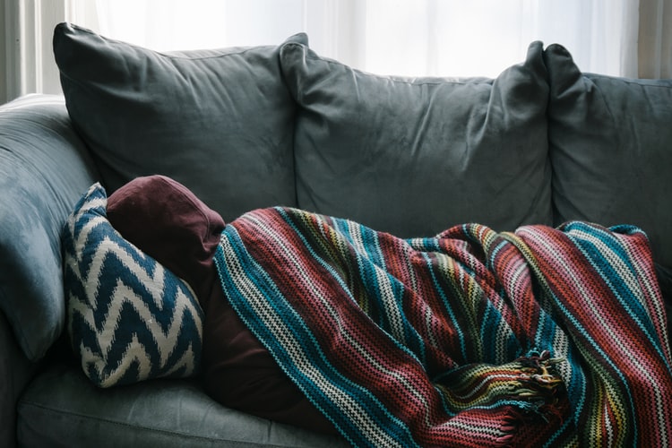 người bị ốm nằm trên sofa.