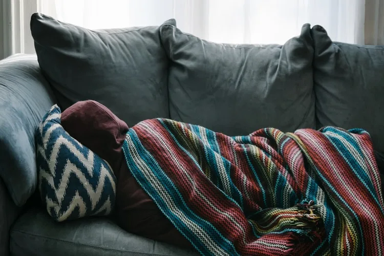 người bị ốm nằm trên sofa.