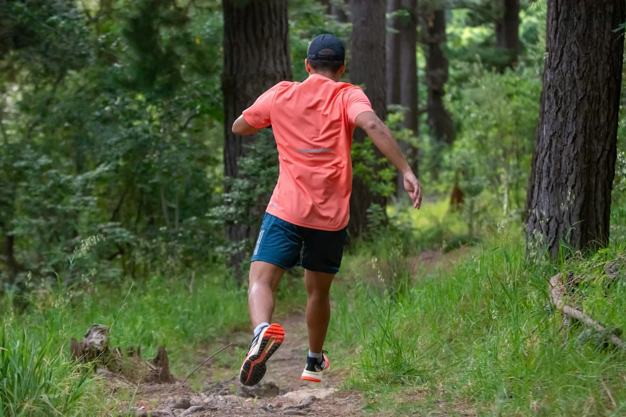 người đàn ông chạy xuống dốc khi chạy trail