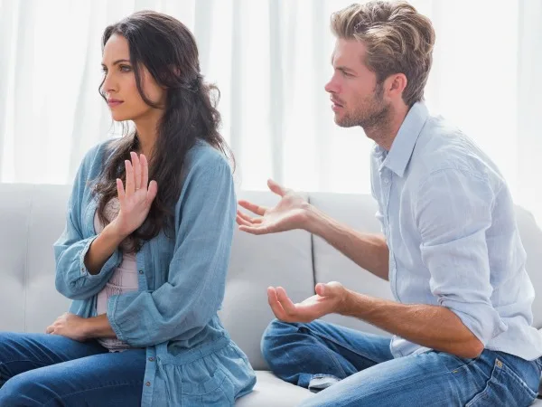 Woman gesturing while quarreling with her partner in the living room