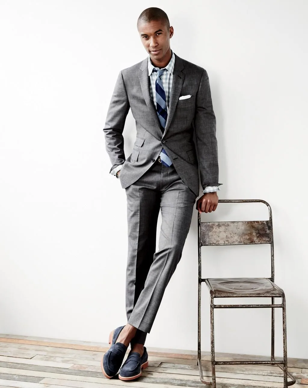 người đàn ông mặc suit xám với giày loafer da lộn.
