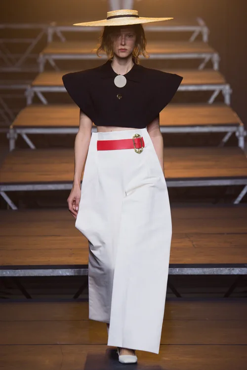 Simon Porte Jacquemus: người mẫu mặc áo crop top đen, quần trắng ống rộng.