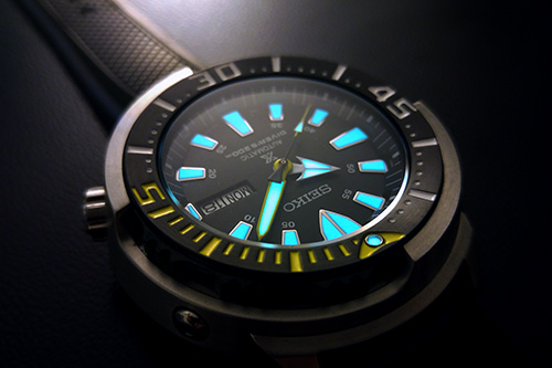 đồng hồ nam Seiko màu đen, chí tiết xanh và vàng.