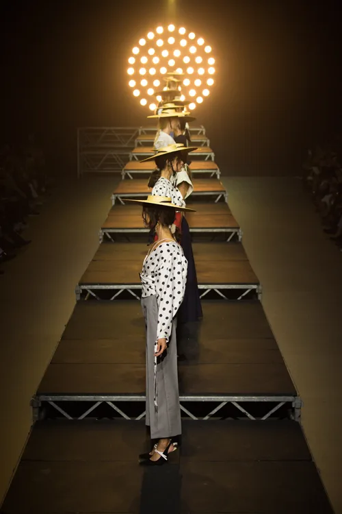 Simon Porte Jacquemus: Người mẫu đứng dọc theo runway, phía sau là dàn đèn chiếu Ready-to-Wear tại Paris Fashion Week 2017.