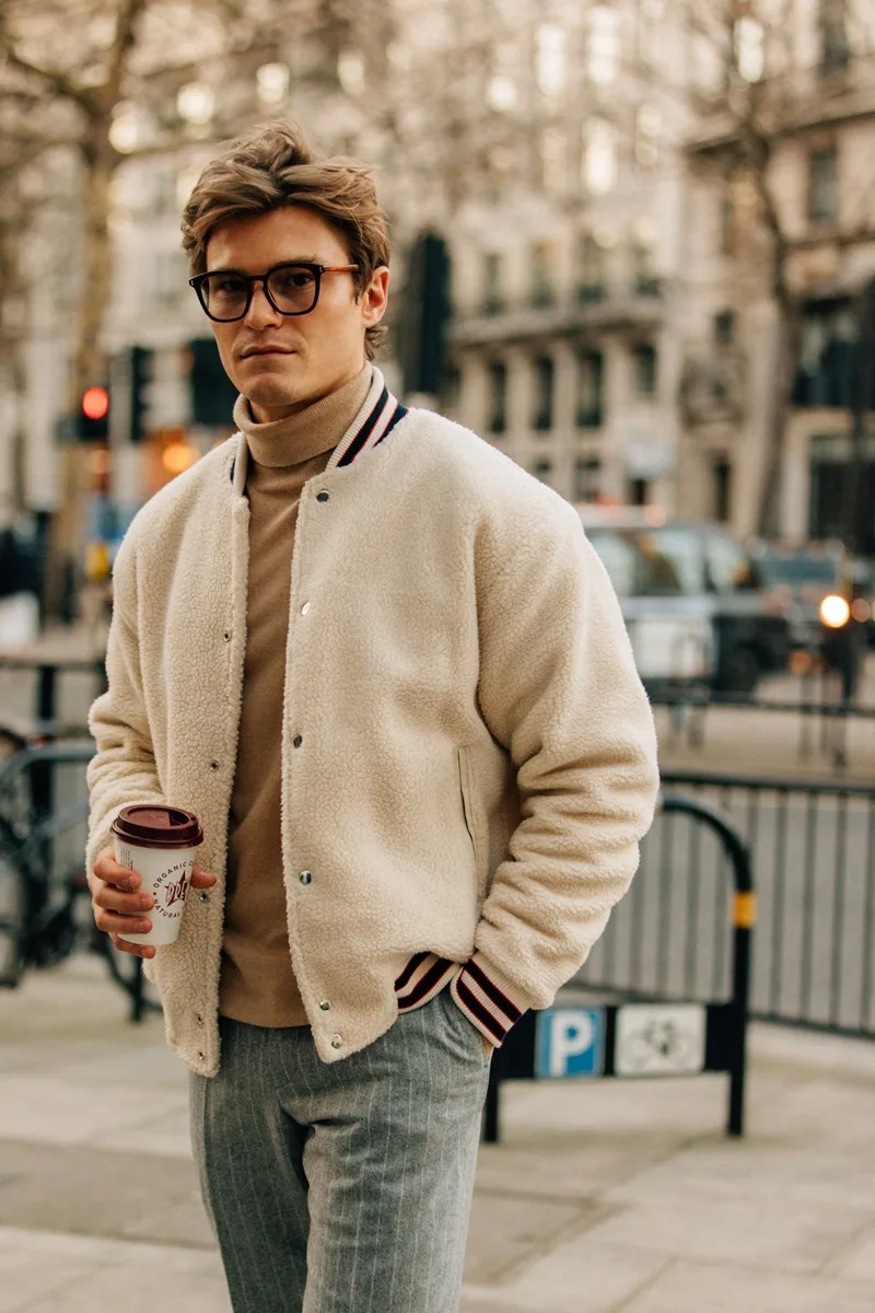 Áo khoác bomber trẻ trung phối cùng áo len cổ lọ và quần jeans wash tạo cái nhìn trẻ trung. Ảnh: GQ