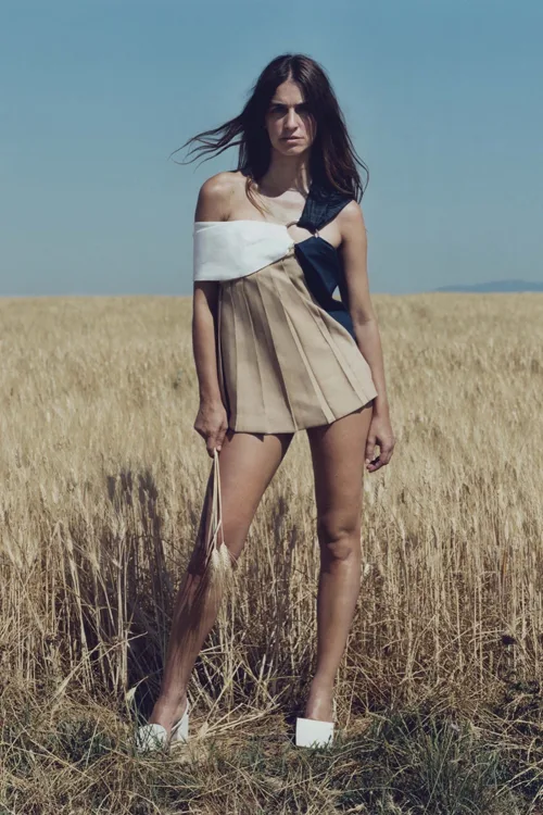 Simon Porte Jacquemus, người mẫu váy ngắn màu biege trên đồng cỏ lau.