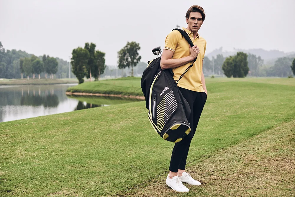 ao thun polo - chang trai mac ao polo vang va quan tay den cam gio danh golf - elle man