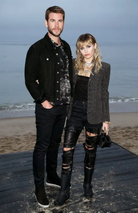 Miley Cyrus cùng Liam Hemsworth đến dự show diễn của Saint Laurent tại thành phố Malibu. Ảnh: E! News