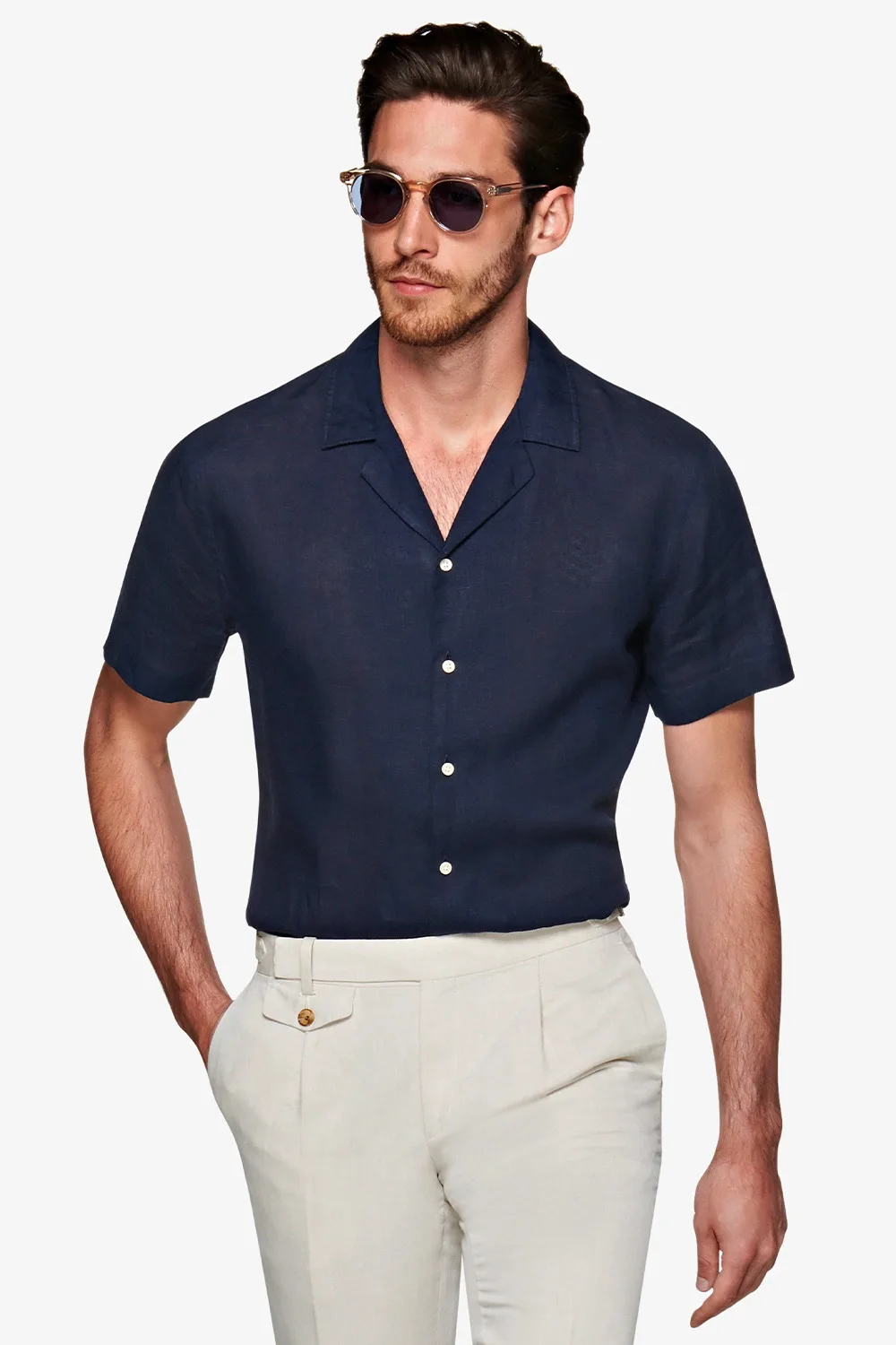 Người mẫu mặc áo sơ mi ngắn tay màu xanh navy và quần trắng ngà của suitsupply.